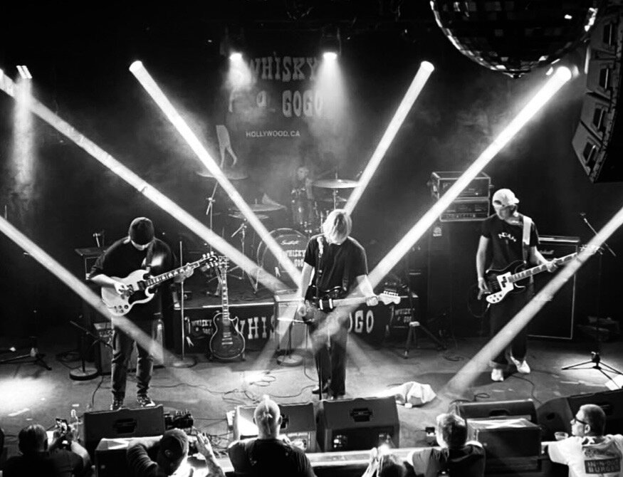 Bleu Grave playing the Whisky a Go Go in Hollywood, searchlights crossing the stage over the band and a full crowd in front of them.