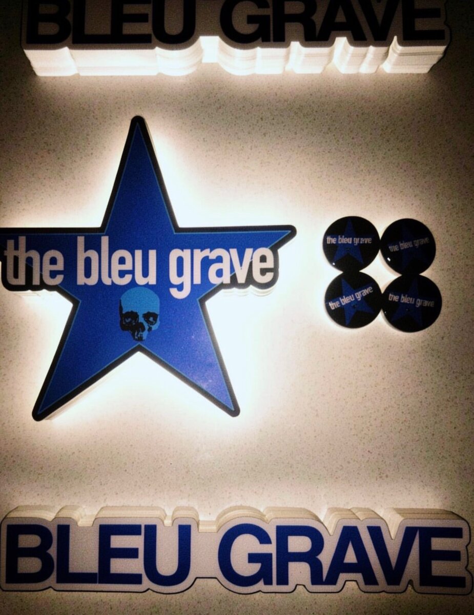 Bleu Grave stickers and pins: a blue star logo sticker and round pins reading "the bleu grave".